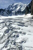 two people are hiking up a mountain with snow covered mountains photo