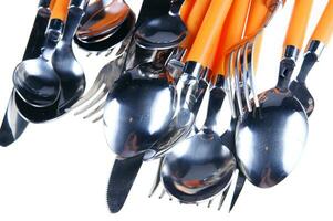 a white dish rack with orange and silver utensils photo