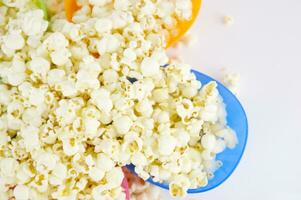 four colorful bowls of popcorn on a white surface photo