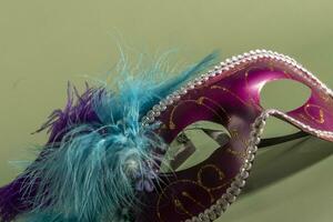 Venetian carnival mask with feathers, and typical elements in the background photo