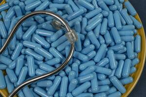 Yellow plate full of blue medicine capsules representing drug overdose photo