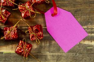 elementos decorativos de navidad junto a la tarjeta con cinta roja y espacio para escribir foto