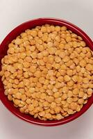 Red lentil in bowl isolated on pink background. Top view photo
