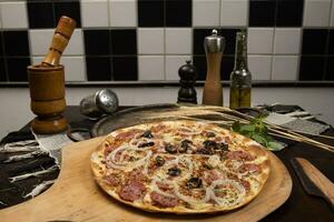 Brazilian pizza with pepperoni, cheese, onion and black olive photo