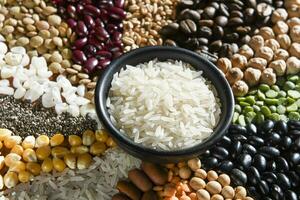 Bowl with raw white rices on various seeds grain photo