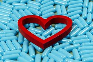 heart shape and blue capsules. Importance of medication treatment photo