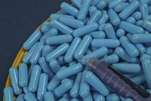 Yellow plate full of blue medicine capsules representing drug overdose photo