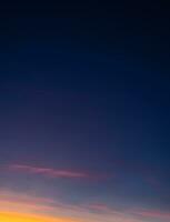 puesta de sol con un vistoso cielo en naranja, púrpura y oscuro azul, vertical crepúsculo en el noche con un hermosa oscuridad cielo luz de sol en otoño foto