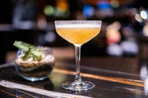 Bright yellow, revitalizing cocktails resting on a bar counter. photo