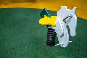 Colorful horse toy set in the playground on the park's lawn. photo