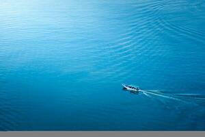 Fishing boat traveling in the beautiful blue sea. photo