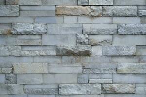 Big and small Bricks in a grey Stone Wall photo