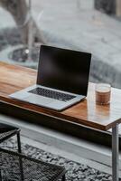 Laptop and a glass of cofee in coffee shop photo