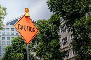 Caution sign ont he street with orange color photo