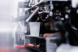 Espresso machine pours fresh black coffee closeup photo