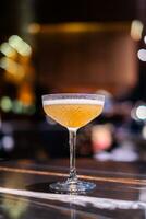 Bright yellow, revitalizing cocktails resting on a bar counter. photo