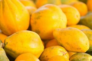 apilar de papayas en un mercado puesto foto