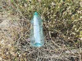 plastic trash bottle on ground. ecology concept. photo