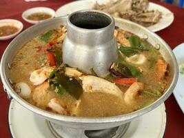 close up view of delicious asian food, spicy seafood tom yum soup photo