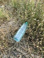 plastic trash bottle on ground. ecology concept. photo