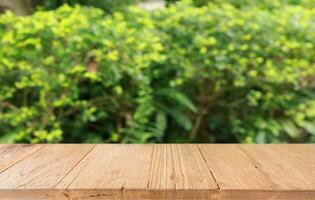 vacío madera mesa parte superior y difuminar de fuera puerta jardín antecedentes vacío de madera mesa espacio para texto márketing promoción. blanco madera mesa Copiar espacio foto