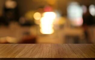 Empty wooden table in front of abstract blurred background of coffee shop . can be used for display or montage your products.Mock up for display of product photo