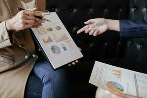 Businesswoman in suit making presentation explaining charts. and discussing a new business project with the members. photo