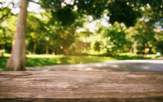 image of wooden table in front of abstract blurred background of outdoor garden lights. can be used for display or montage your products.Mock up for display of product photo