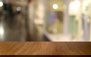 vacío de madera mesa en frente de resumen borroso antecedentes de café tienda . lata ser usado para monitor o montaje tu productos.mock arriba para monitor de producto foto