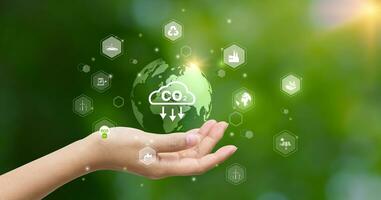 CO2 emission reduction concept.world icon in hand with environmental icons, Ideas for Sustainable development, and green business based on renewable energy. Energy saving, Sustainable development. photo