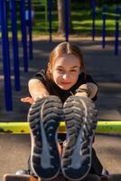 A teenage girl doing abdominal crunches. photo