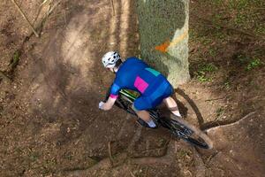 Man riding a mountain bike through a wooded area on summer day. photo