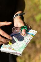 Woman holding a map and the compass during orienteering competitions. photo