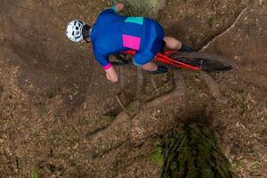 Man riding a mountain bike through a wooded area on summer day. photo