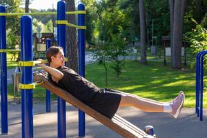 A teenage girl doing abdominal crunches. photo