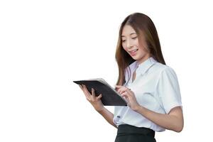 Portrait of an Asian Thai girl student in uniform is standing smiling happily and confidently while using tablet in building at the university while isolated on white background. photo