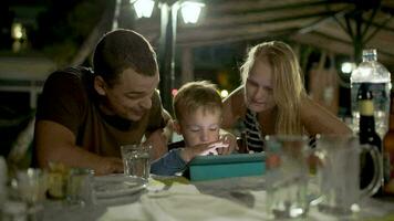 Family with tablet PC in outdoor cafe video