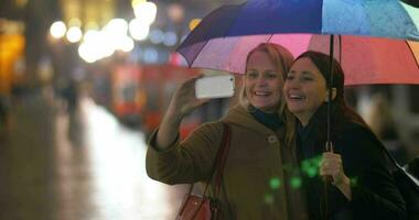 fêmea amigos fazer selfie debaixo arco Iris guarda-chuva video