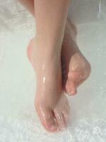 a person's bare feet in a bathtub photo