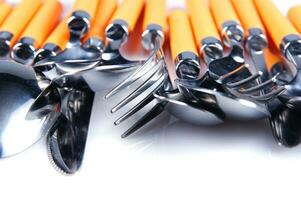 a white dish rack with orange and silver utensils photo