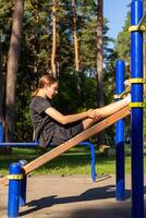 A teenage girl doing abdominal crunches. photo