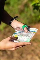 mujer participación un mapa y el Brújula durante orientación competiciones foto