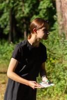 Young girl in forest reading map and searching for a control point. Sports orienteering competition. photo