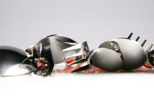 a white dish rack with orange and silver utensils photo