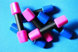 a pile of blue and pink plastic toys on a wooden floor photo