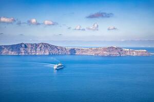 Beautiful landscape with sea view. Cruise liner at the sea near the islands. Santorini island, Greece. Summer transportation landscape, seascape with cruise ships on blue sea photo