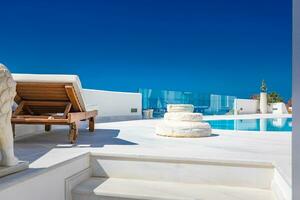 Luxury summer travel and vacation, loungers and swimming pool with white architecture. Tranquil view of summer resort or hotel. Fantastic summer mood, relaxing vibes photo