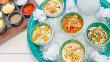 ceviche gastrónomo mar comida en blanco mesa. delicioso ceviche de camarón con verduras, especias y Lima cerca arriba en un lámina. lujo al aire libre restaurante con mar antecedentes y soleado clima foto