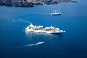 Beautiful landscape with sea view. Cruise liner at the sea near the islands. Santorini island, Greece. Summer transportation landscape, seascape with cruise ships on blue sea photo