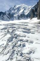 two people are hiking up a mountain with snow covered mountains photo